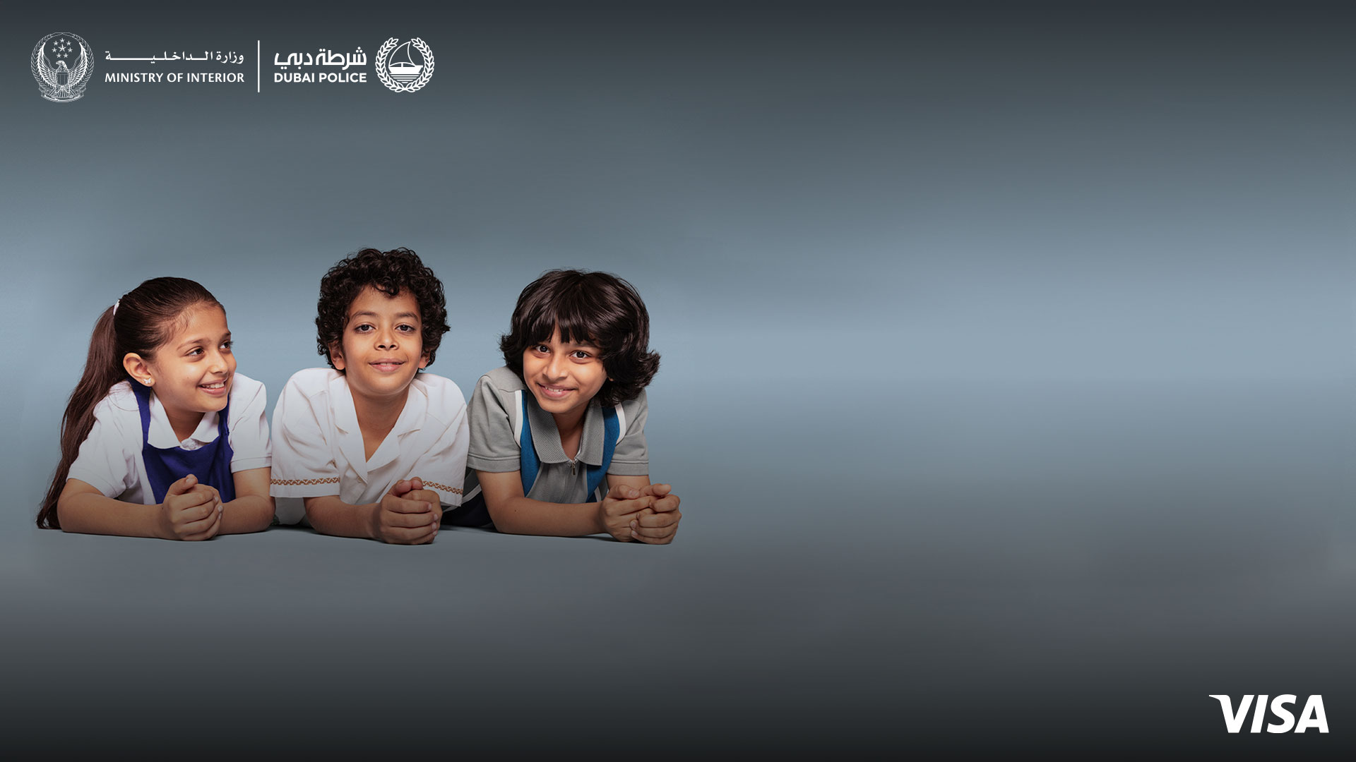 Two children look directly at the camera, one child looks at the two children