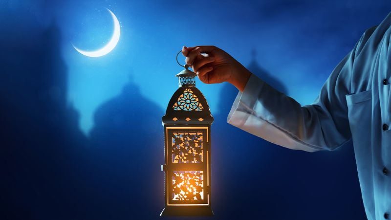 Night lamp in hand against the moon