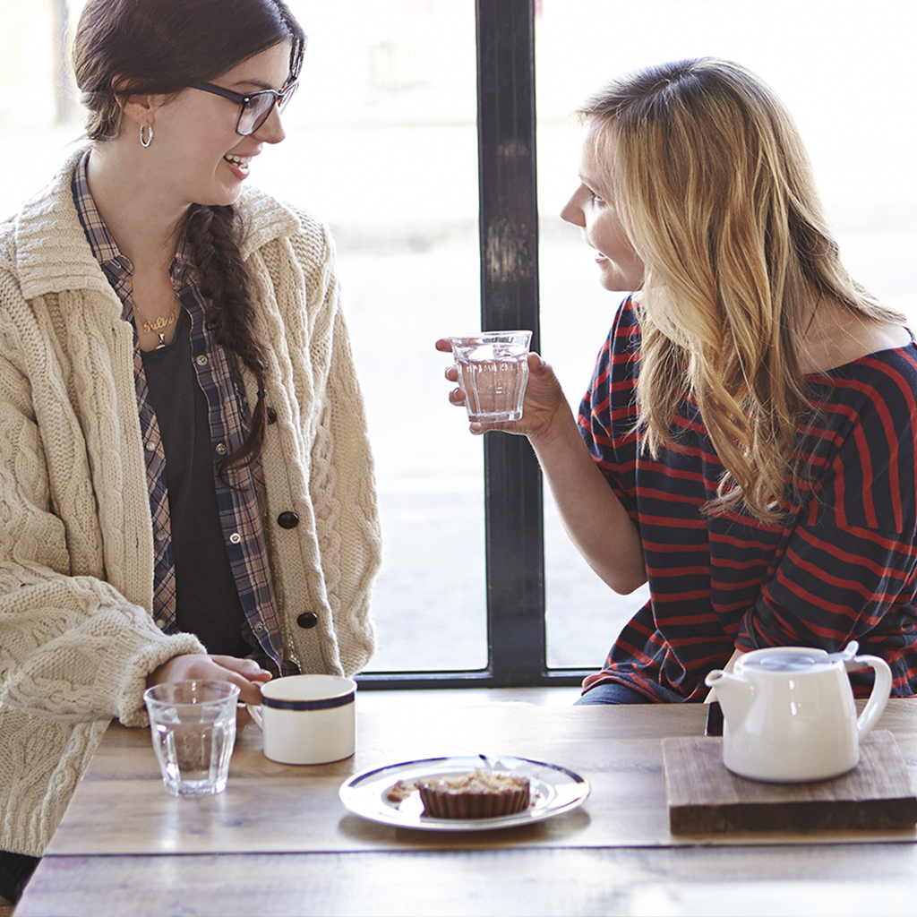 Two women talking in a coffee shop.
