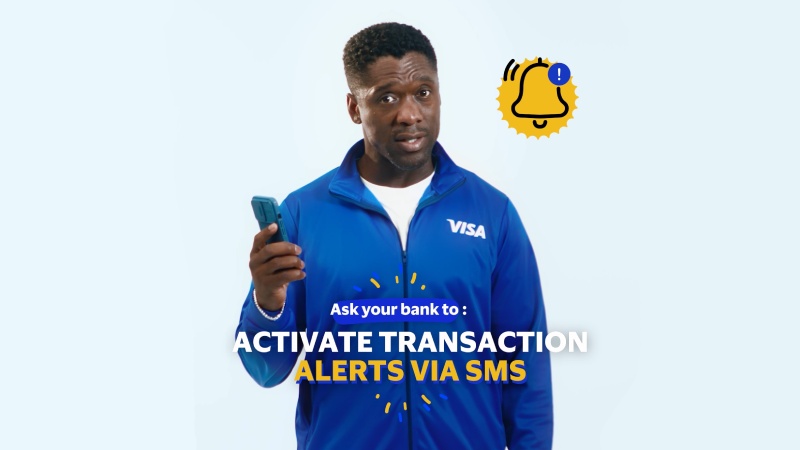 Clarence Seedorf holding a phone and proposing to activate transaction alerts via sms