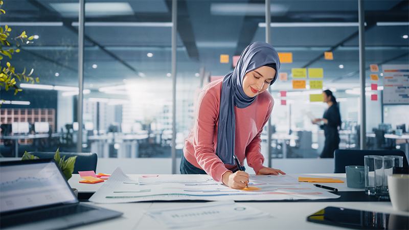 A woman in a hijab working on a project